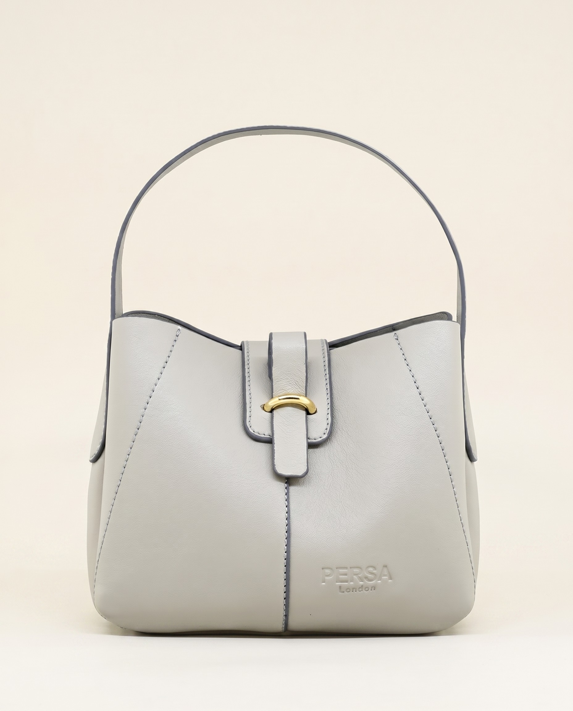 Front detail of the Persa London mini bag — gold clasp with embossed Persa London mark on cream leather